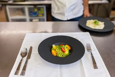 Freshly cooked noodles and pasta arranged neatly on a white dish

