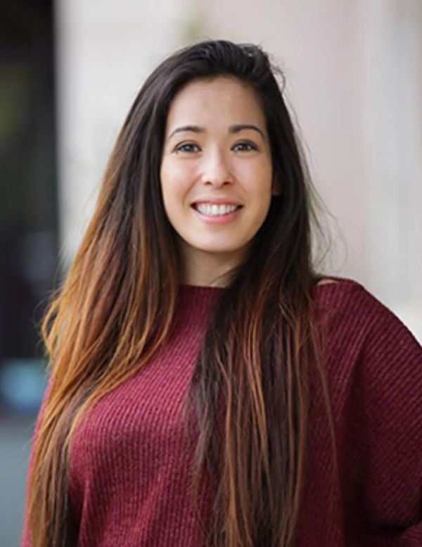 Smiling woman with long hair in a red sweater.