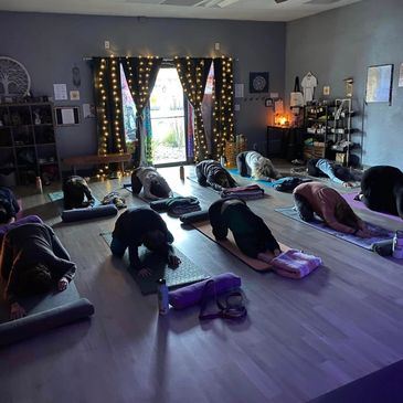 Group doing yoga in a dimly lit studio.