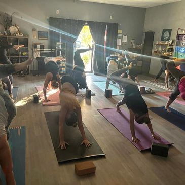 Group doing yoga in a sunlit room.