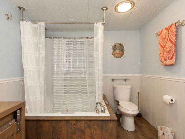 Cozy bathroom with wooden bathtub surround and soft lighting.