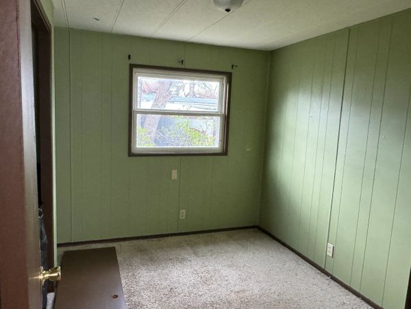 Empty small room with green walls and a single window.