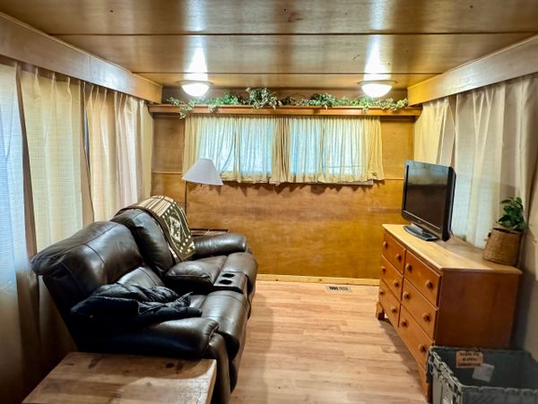 Cozy living room with leather sofa and wooden furniture in a compact space.