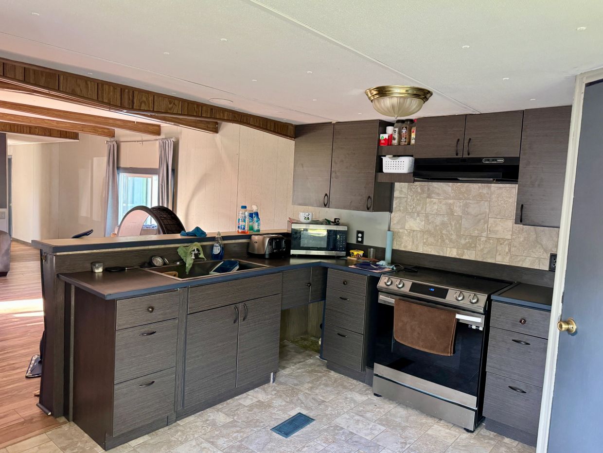 Modern kitchen with black countertops and stainless steel stove.