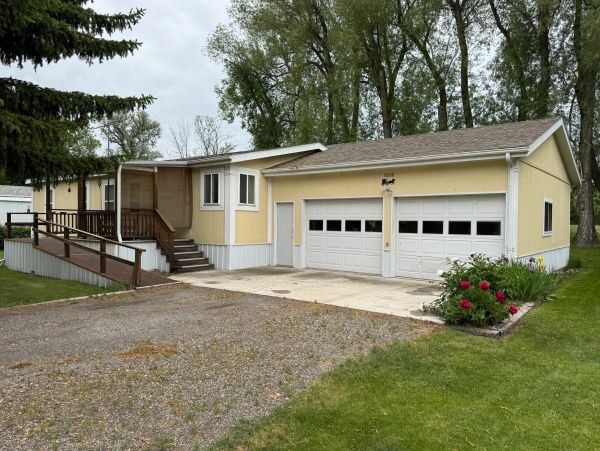 Yellow house with double garage and front porch.