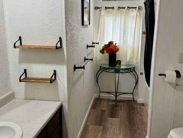 Narrow room with shelves, hooks, table, and window.