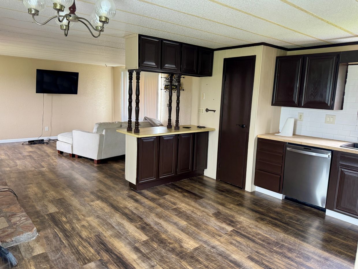 Open living space with dark wood cabinets and light furniture.