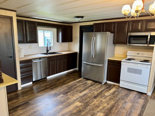 Modern kitchen with dark cabinets and stainless appliances.
