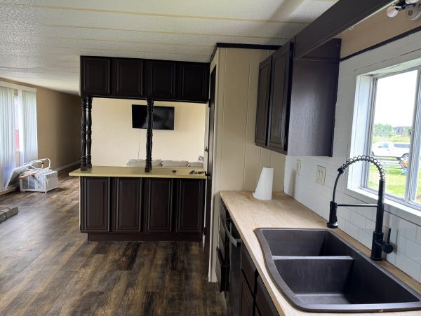 Modern kitchen with dark cabinetry and wood flooring.