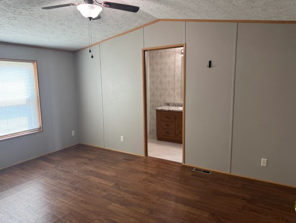 Empty room with wood floor and ceiling fan.
