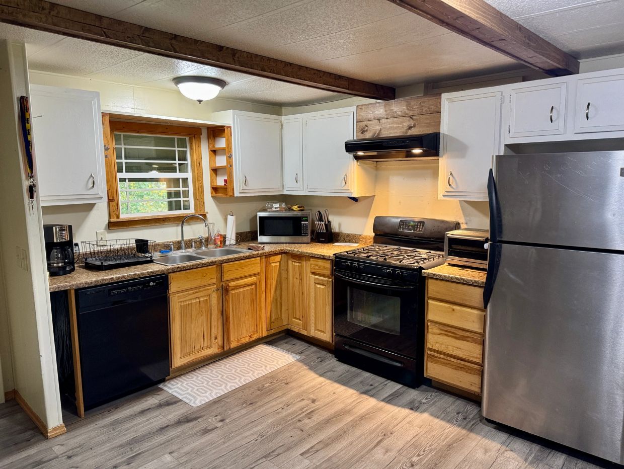 Rustic kitchen with wooden cabinets and modern appliances.