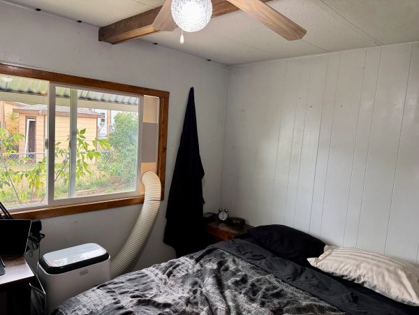 Cozy room with bed, window, and air conditioner.