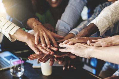 A group of people with their hands together to symbolize teamwork