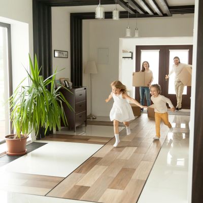 Playful happy kids running into new big own beautiful house