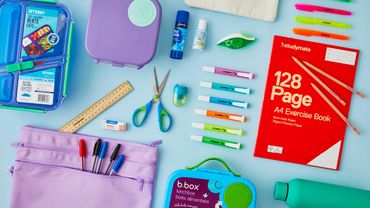 Colorful school supplies neatly arranged on a light blue surface.