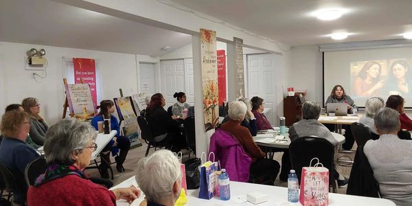 Group of people attending a presentation in a community room.
