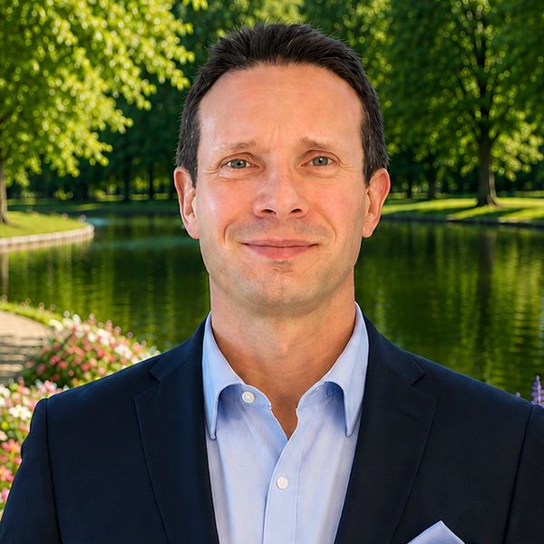 Professional man in a suit standing by a peaceful park pond.