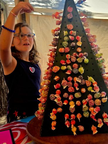 Girl arranging colorful candy on a display stand.