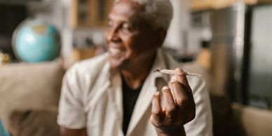 A black man holding a joint.