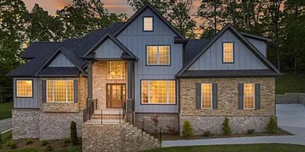 Large modern house with illuminated windows at dusk.