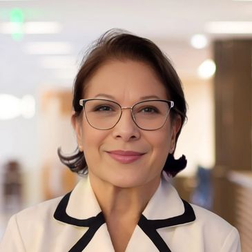 A Latino business woman with glasses smiling