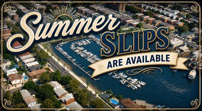 Aerial view of a marina with boats and a banner advertising summer slips available.