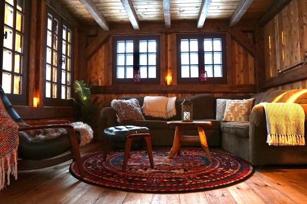 Cozy wooden cabin living room with warm lighting and rustic furniture.