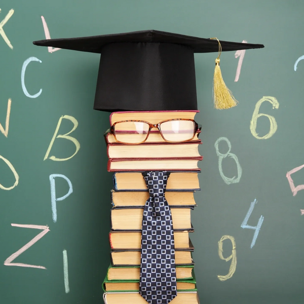 Book stack with with glasses, tie, and graduation hat.