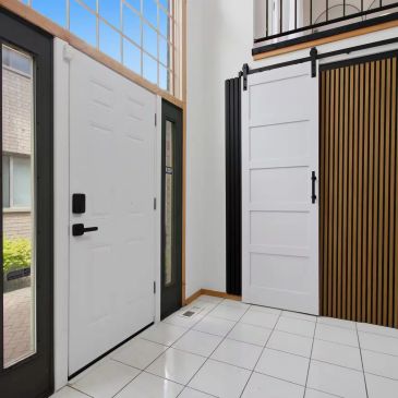 Modern entryway with white doors and tile flooring.