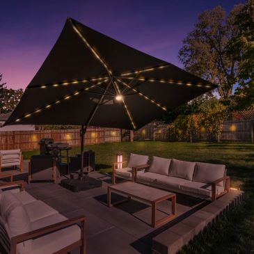 Cozy outdoor patio setup with lit umbrella at dusk.