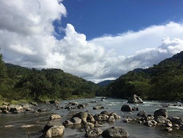 Río rodeado de montañas y cielo nublado.