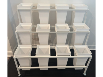 A white multi-level display stand with square containers.
