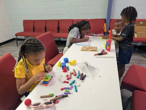 Children engaged in creative play and learning activities at a table.