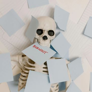 Skeleton surrounded by sticky notes, one labeled 'BURNOUT'.