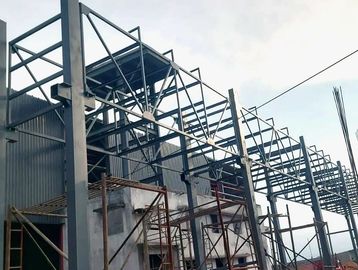 Steel framework structure under construction against a cloudy sky.