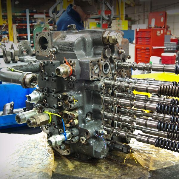 Complex hydraulic valve assembly in an industrial workshop.