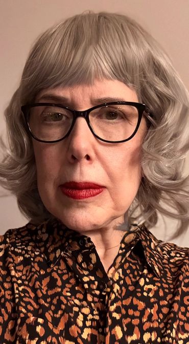 Older woman with silver hair and glasses.