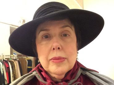 Woman wearing a black wide-brimmed hat.
