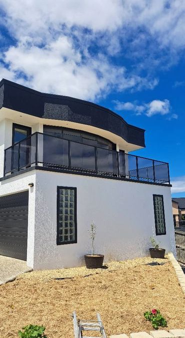 Modern two-story house with black and white exterior under a blue sky.