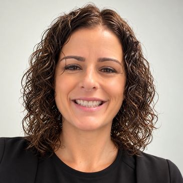 Smiling woman with curly hair and black top.
