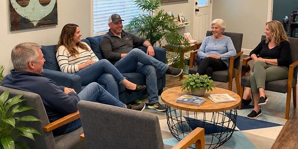 A group of five people chatting in a cozy living room.