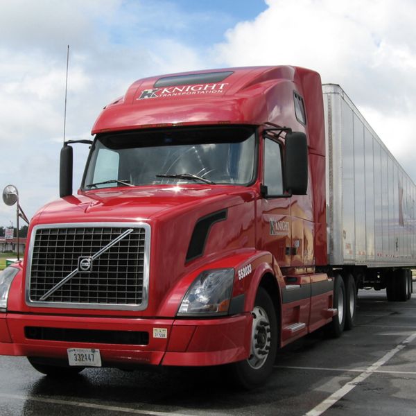 Red Knight Transportation semi-truck parked with trailer attached.