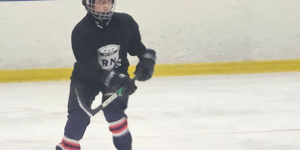 Young Rink Nation athlete looking intensely at the puck and play