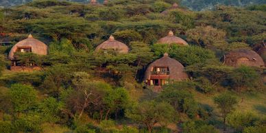 Thatched-roof huts nestled in lush greenery.