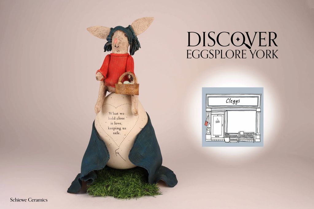 Schiewe Ceramic Cleggs rabbit holding easter egg basket, sat on a big easter egg with blanket on it.