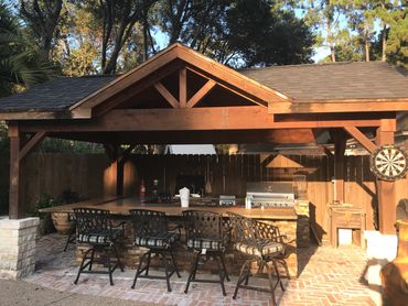 Outdoor kitchen with custom stone countertops, built-in grill, and patio design enhancing backyard