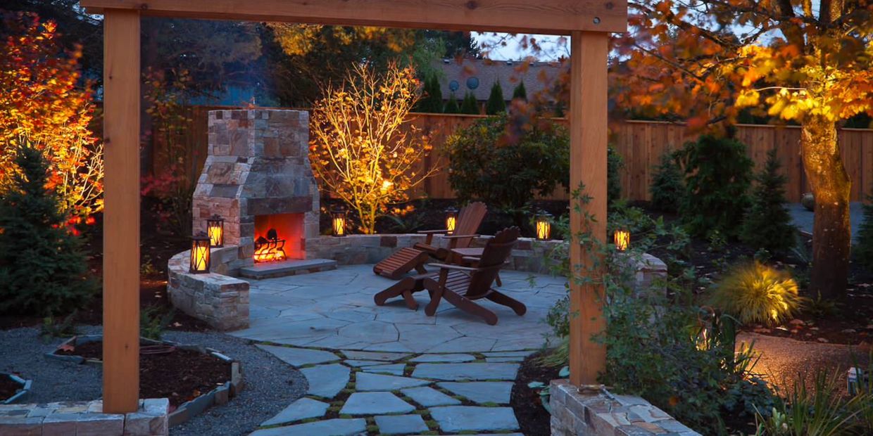 Backyard transformation with firepit installation, landscape lighting, and outdoor seating area.
