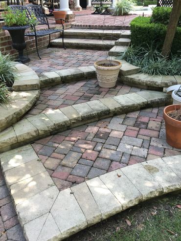 Curved garden walkway with decorative pavers and surrounding landscape design