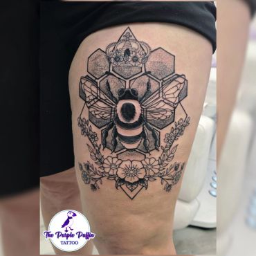 Black and white bee tattoo with hexagons and floral elements.