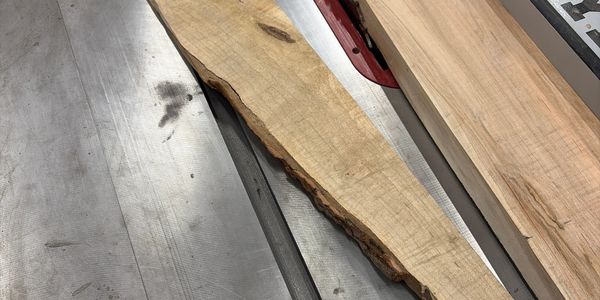 Two pieces of wood on a metal table saw surface.